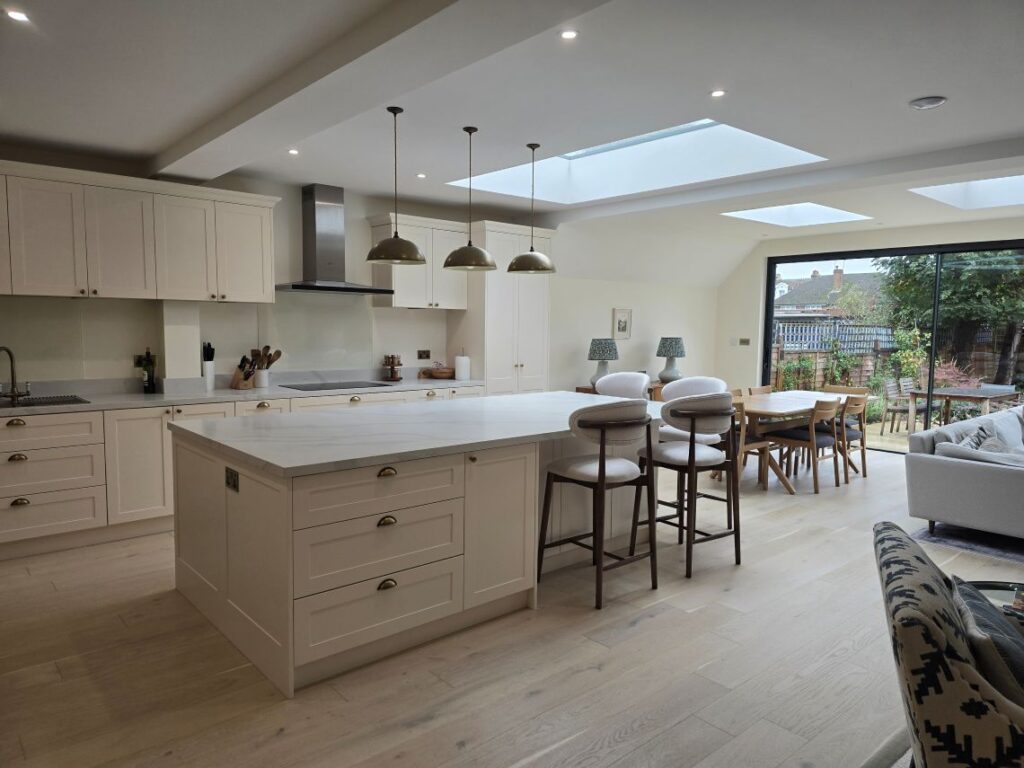 Open-plan kitchen with large island, rooflights and sliding doors to the garden in a full house refurbishment and extension in Richmond TW9 conservation area.